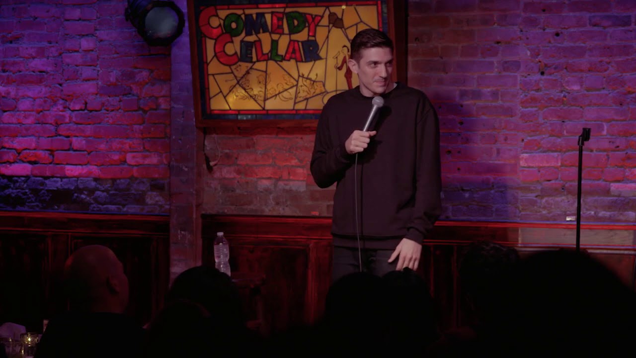 Schulz on stage at the Comedy Cellar. Photo by: YouTube