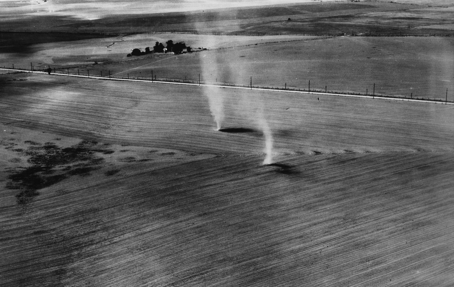 Early morning whirlwinds rising from the finely tilled, 'eroded' soil in Walla Walla County, Washington, 16 July 1937.