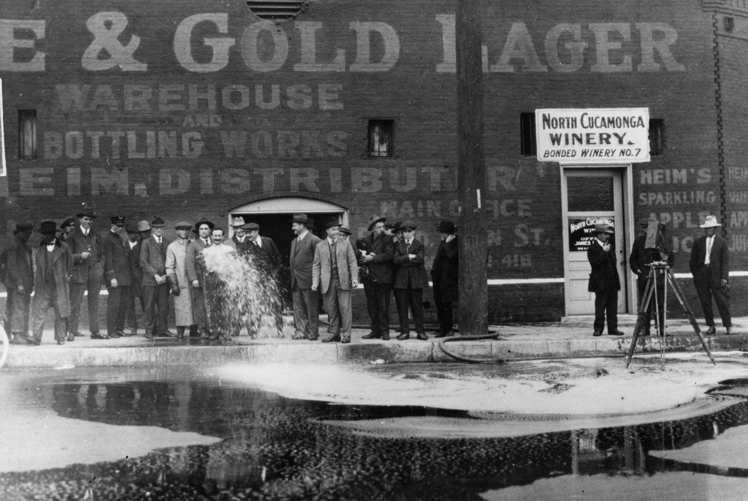 33,100 gallons of wine being flushed into the gutter outside the North Cucamonga Winery in Los Angeles, February 1920 (Getty).
