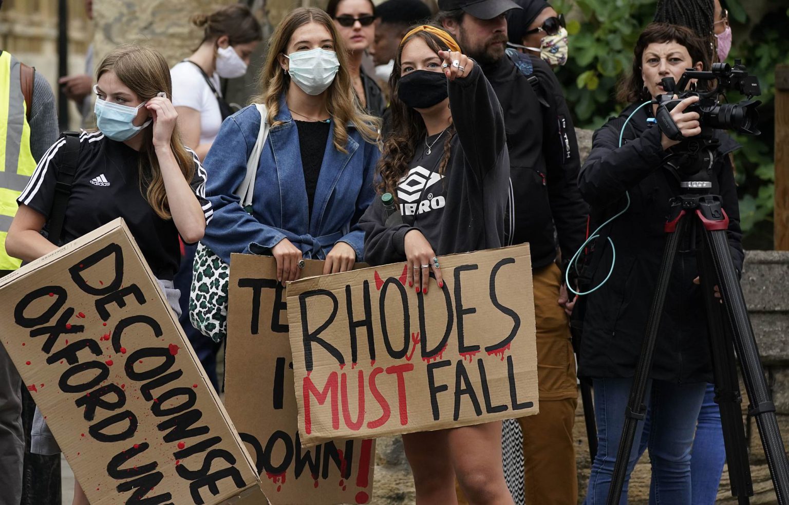 Demonstrators hold placards during a protest called by the Rhodes Must Fall campaign on 9 June 2020 in Oxford.