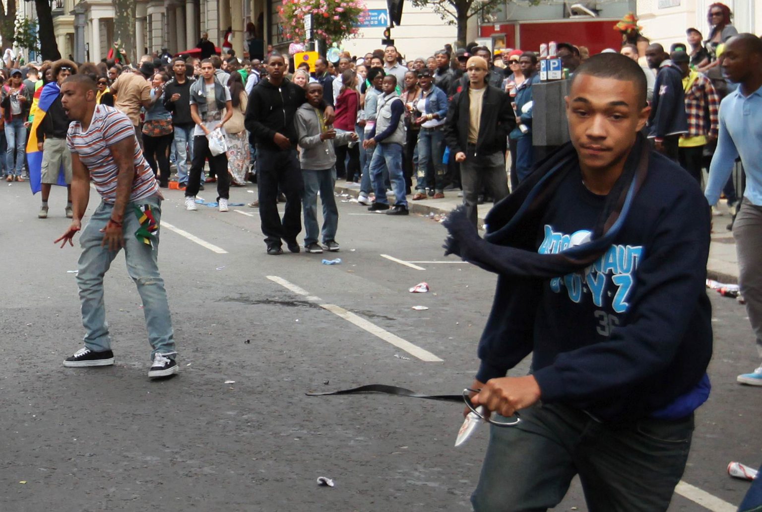 A man carrying a knife runs down the road at the Notting Hill Carnival, 29 August 2011