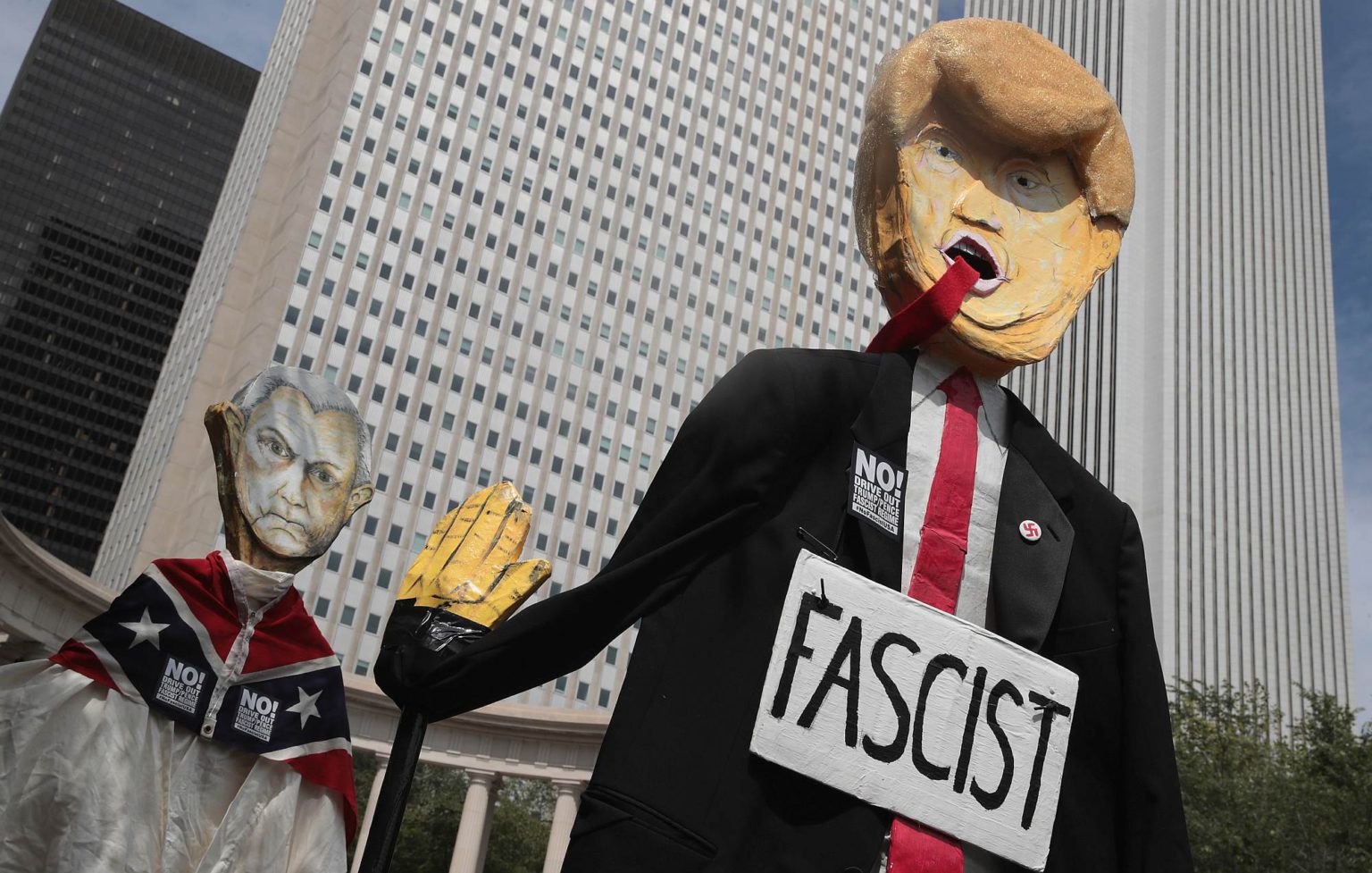 Demonstrators carry puppets of President Donald Trump and US Attorney General Jeff Sessions on 13 August 2017 in Chicago, Illinois.