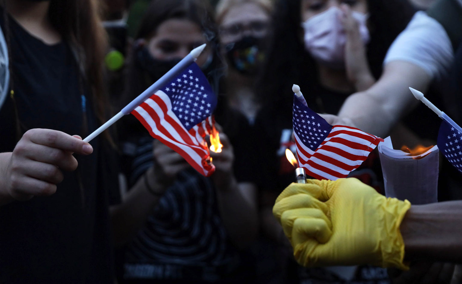 Anti-Trump activists burn US flags at Black Lives Matter Plaza near the White House 4 July 2020.