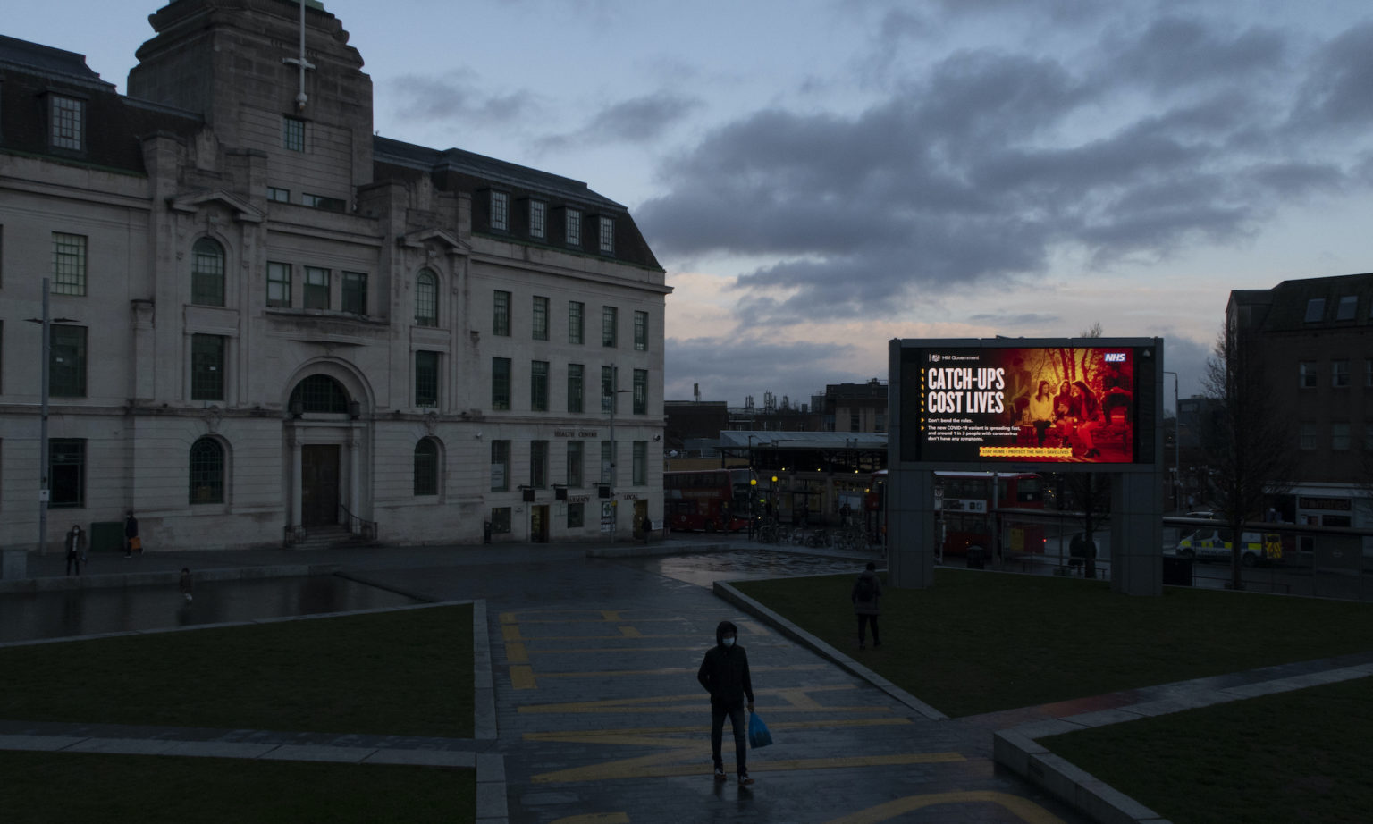 A screen broadcasts a public-service announcement in London, 16 February 2021.