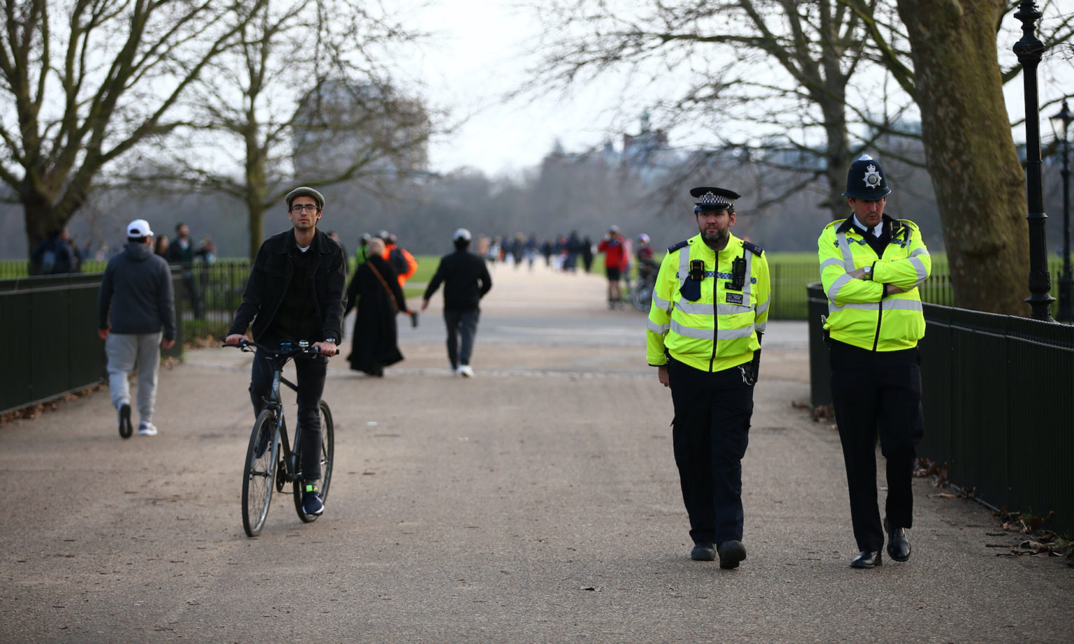 Met police officers patrol as people exercise in Hyde Park, London, England.
