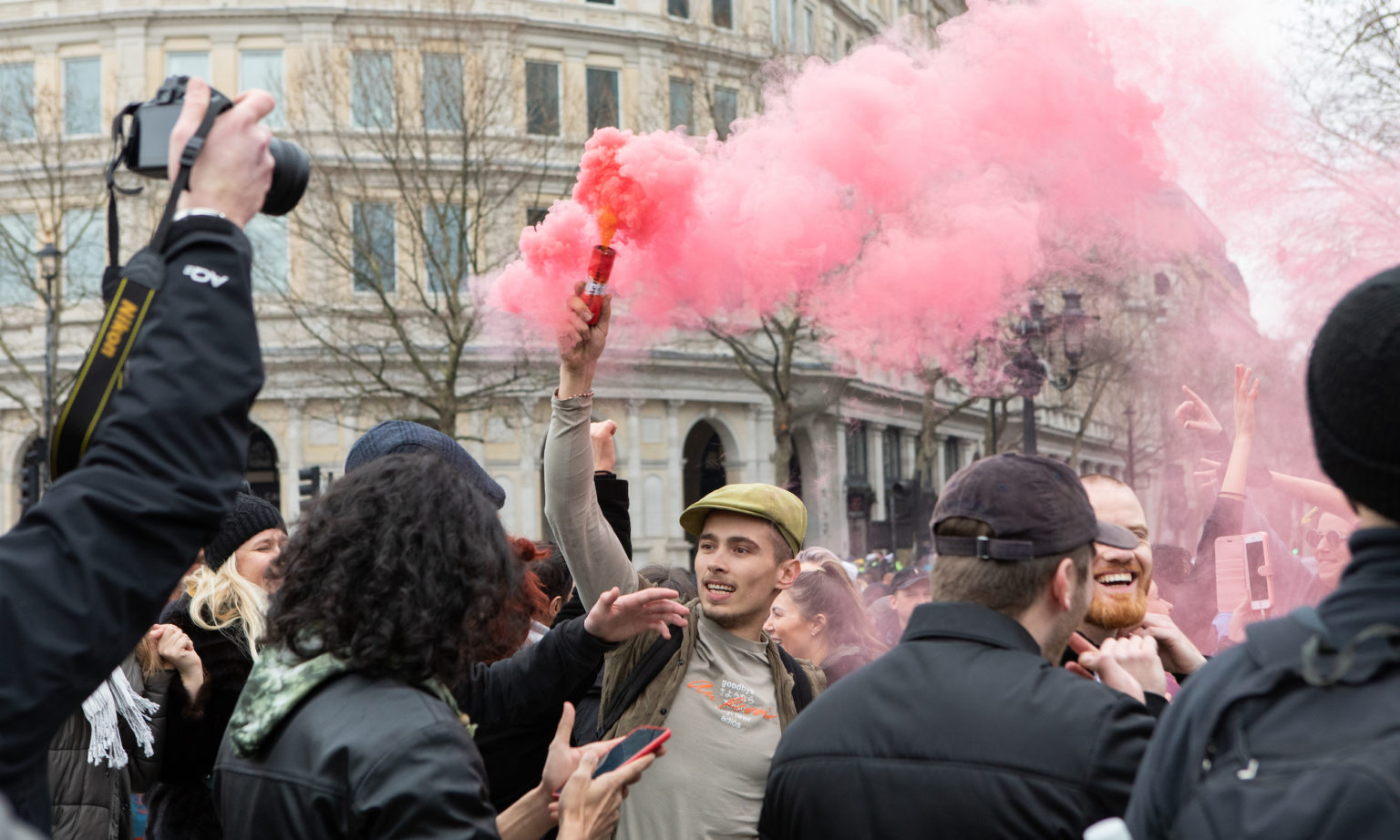 A protester sets off a flare in Trafalgar Square.