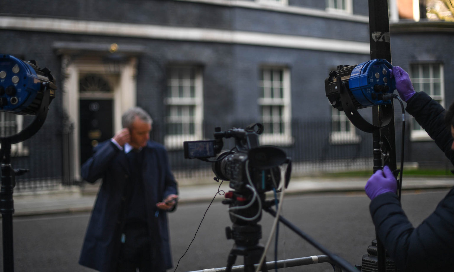A journalist prepares to broadcast from Downing Street, 27 March 2020.