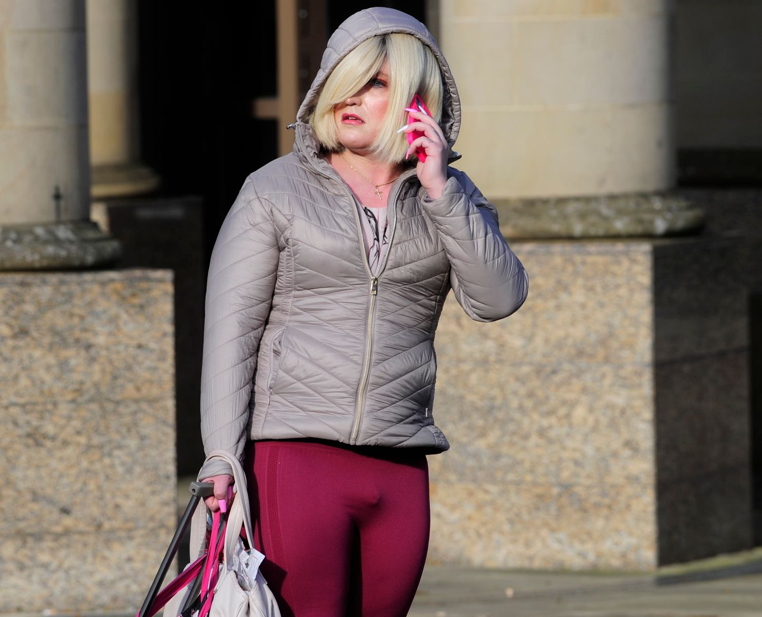 Adam Graham (Isla Bryson) holding his phone and bags.