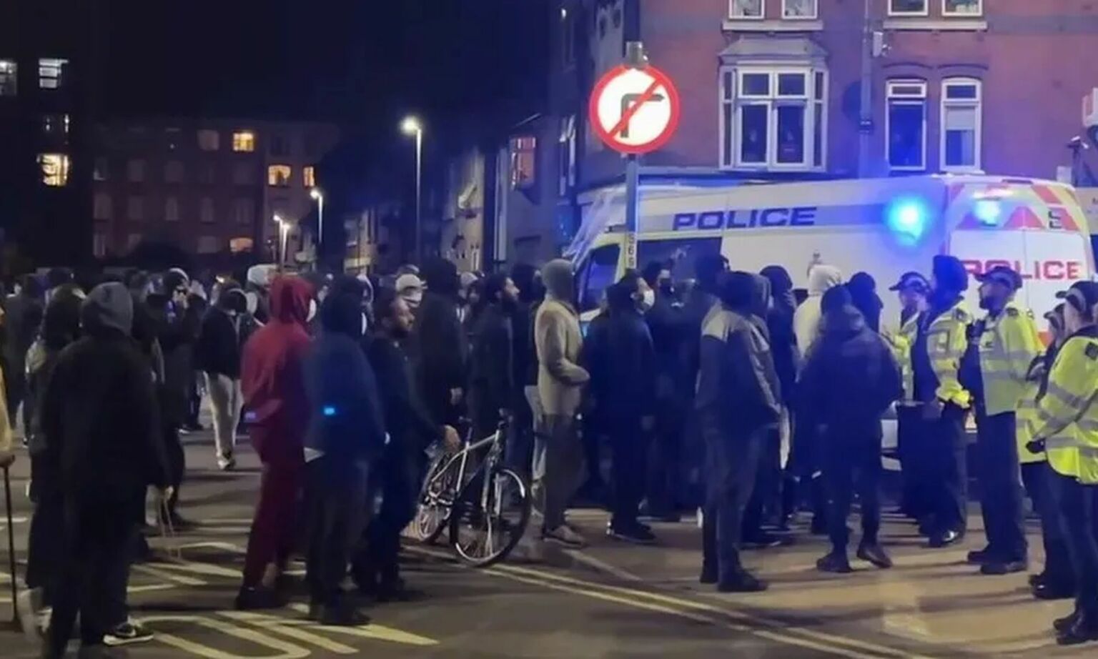 Police hold back crowds of rioters in Leicester, September 2022.