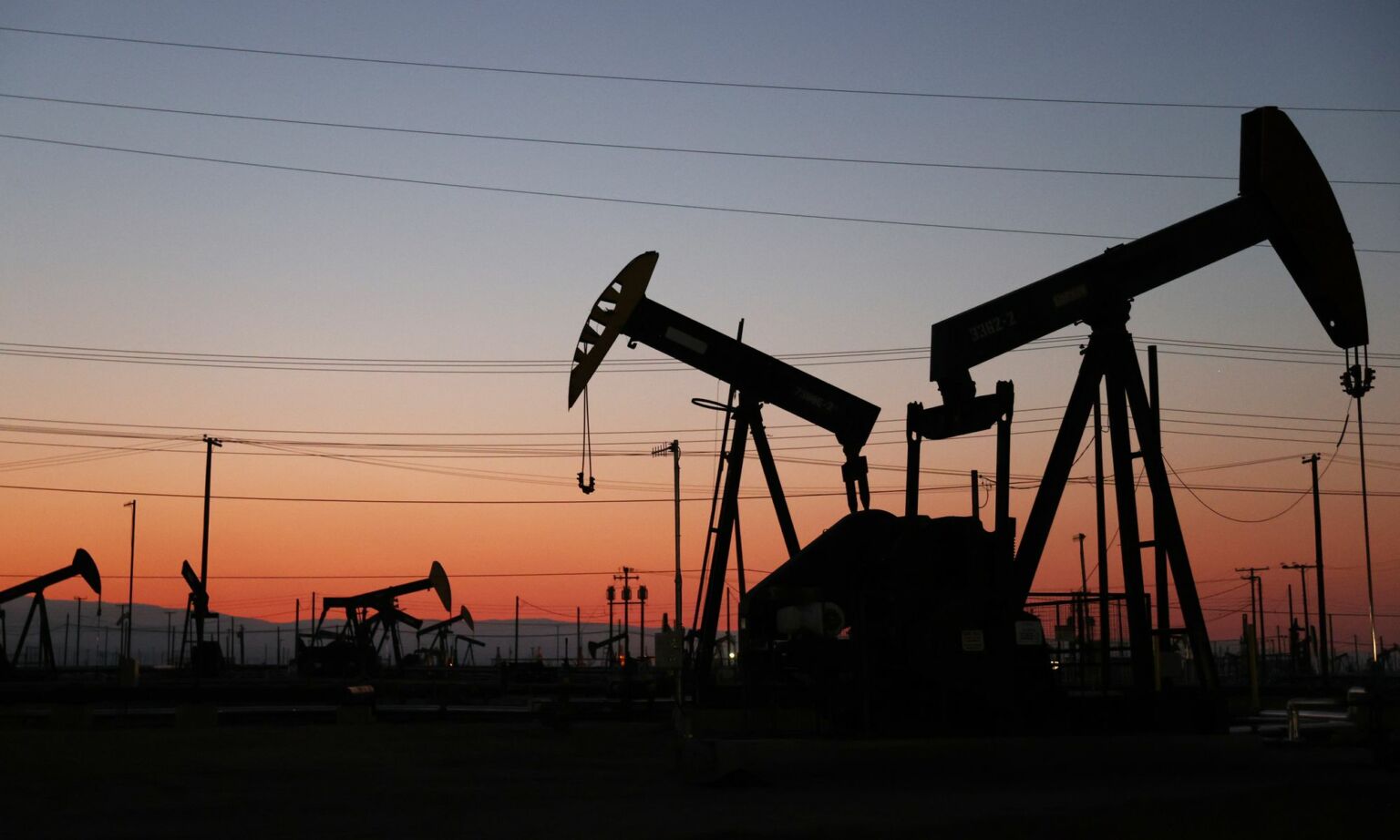 The sun sets beyond pumpjacks in the Belridge oil field on 3 November 2021 near McKittrick, California.