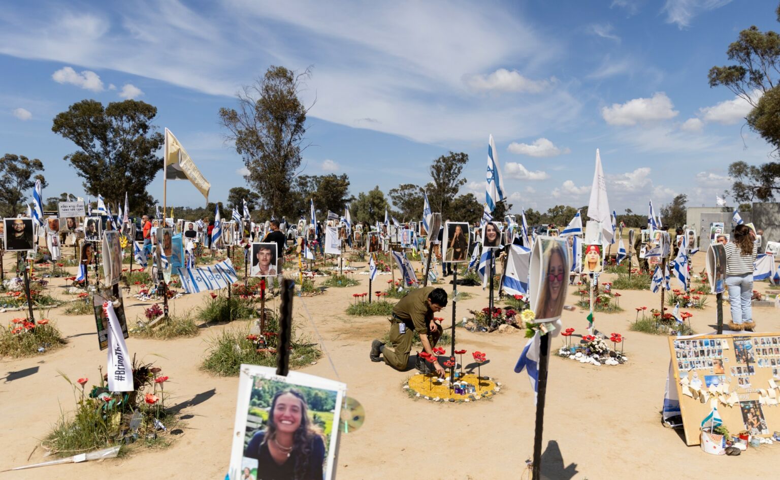 An Israeli soldier pays a tribute for a victim of the massacre at the Nova festival, in Re'im, 25 March 2024.