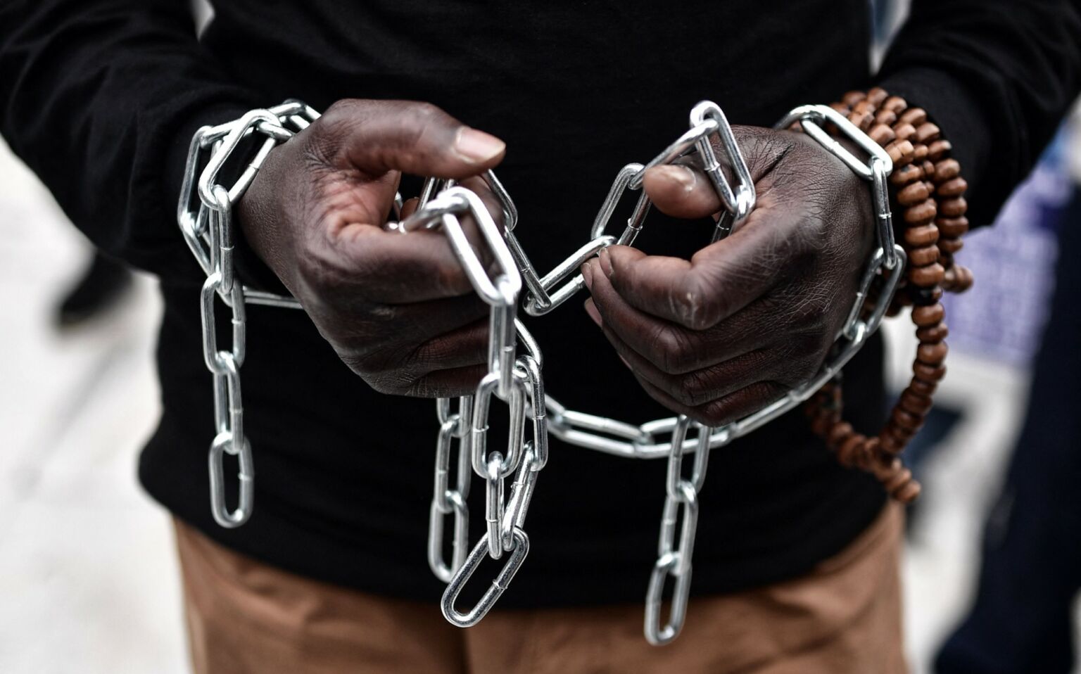 An African migrant with his hands chained, protesting in Brussels against the slavery of migrants in Libya, 2 December 2017