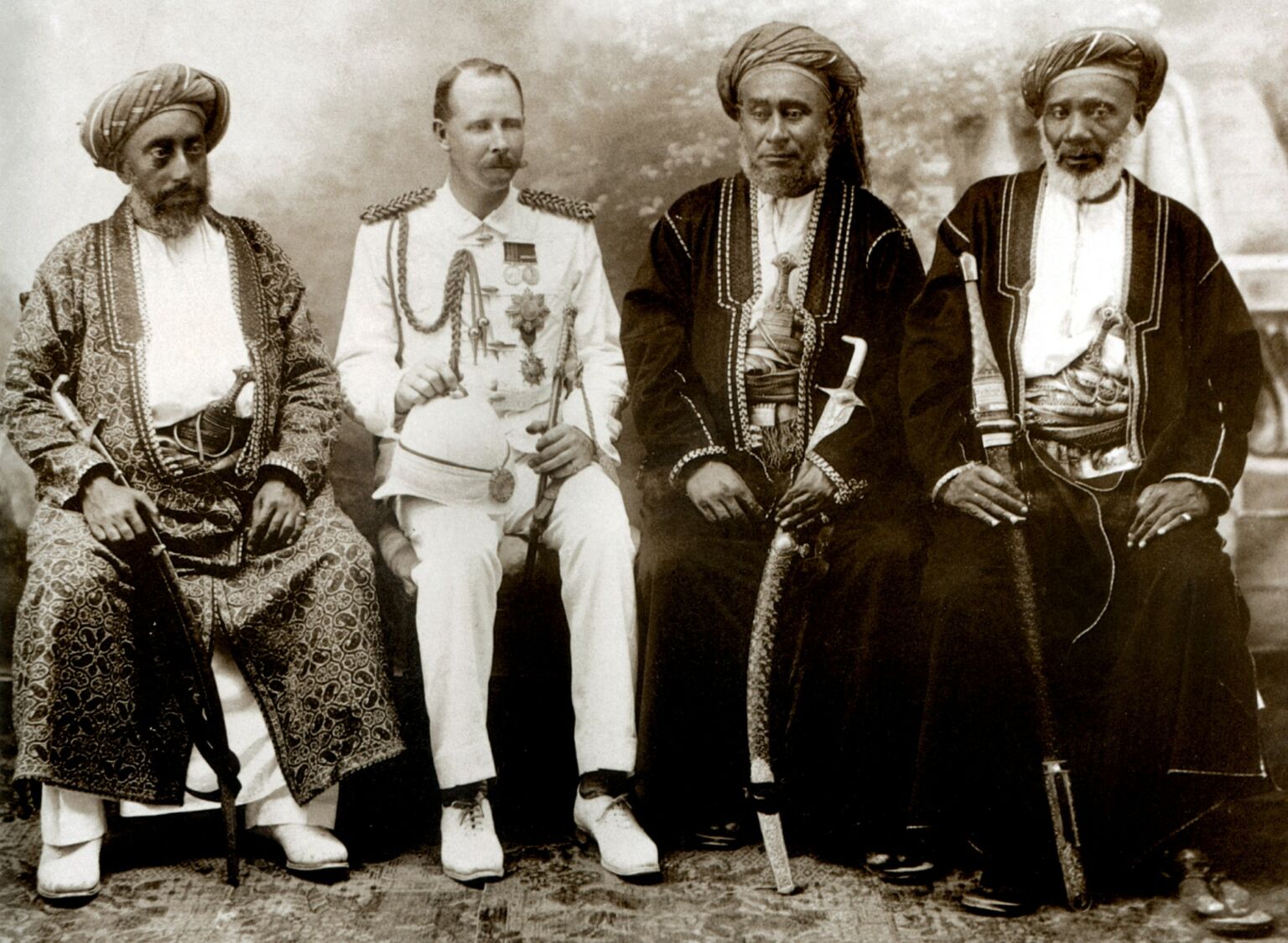 Tippu Tip (far right) sits besides Arab dignitaries and a colonial official. (Date unknown).