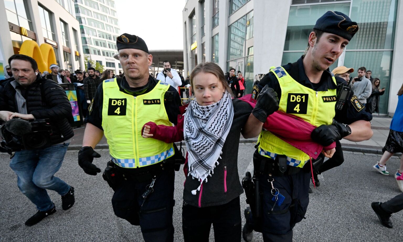 Swedish climate activist Greta Thunberg wearing the keffiyeh scarf is removed by police during a pro-Palestinian demonstration outside the Malmo Arena venue ahead of the final of the 68th Eurovision Song Contest.