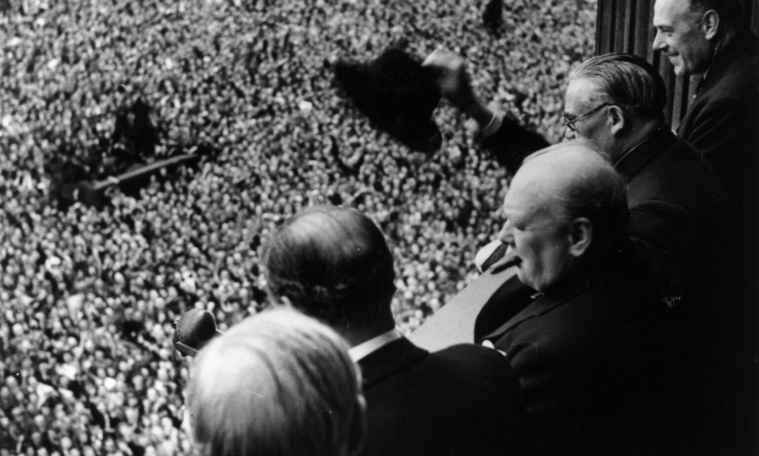 British prime minister Winston Churchill waves to crowds gathered in Whitehall on VE Day, 8 May 1945.