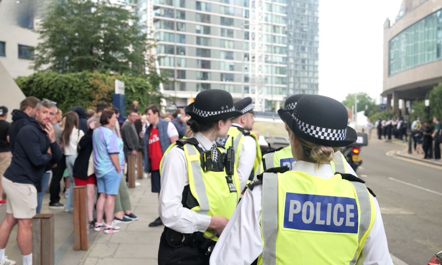 Police officers observe protesters outside the Britannia International Hotel.